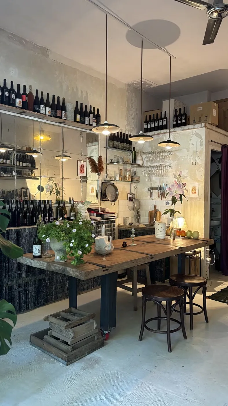La mesa larga de Jugo vacía, bajo las lámparas y con las botellas en la estantería